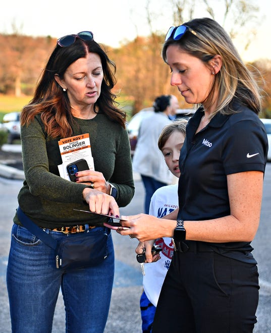 Austin Gladfelter, 9, center, looks on as Veronica Gemma, left, with PA Economic Growth PAC, gives literature to Gladfelter’s mother, voter Jen Gladfelter, right, of Springettsbury Township, as they arrive at their Commonwealth Fire Co No. 1 Station 893 polling location during Election Day in Springettsbury Township, Tuesday, Nov. 7, 2023. (Dawn J. Sagert/The York Dispatch)
