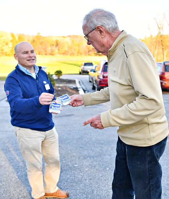 York County Commissioners candidate Scott Burford, hands literature to voter Bill Sonnenberg, of Springettsbury Township, as he and his wife Judy (not pictured) arrive to cast their ballots at their Commonwealth Fire Co No. 1 Station 893 polling location during Election Day in Springettsbury Township, Tuesday, Nov. 7, 2023. (Dawn J. Sagert/The York Dispatch)