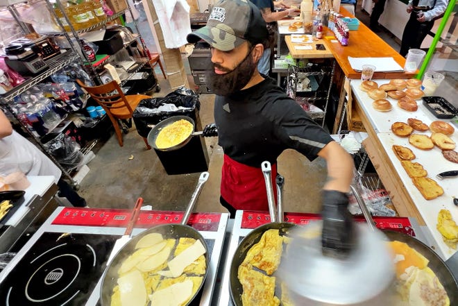 Owner Nathaniel Jamison alternates a lid between frying pans while cooking at The Breakfast Store inside Penn Market in York City, Saturday, Feb. 17, 2024. The eatery offers customized breakfast sandwiches starting at $5. (Dawn J. Sagert/The York Dispatch)