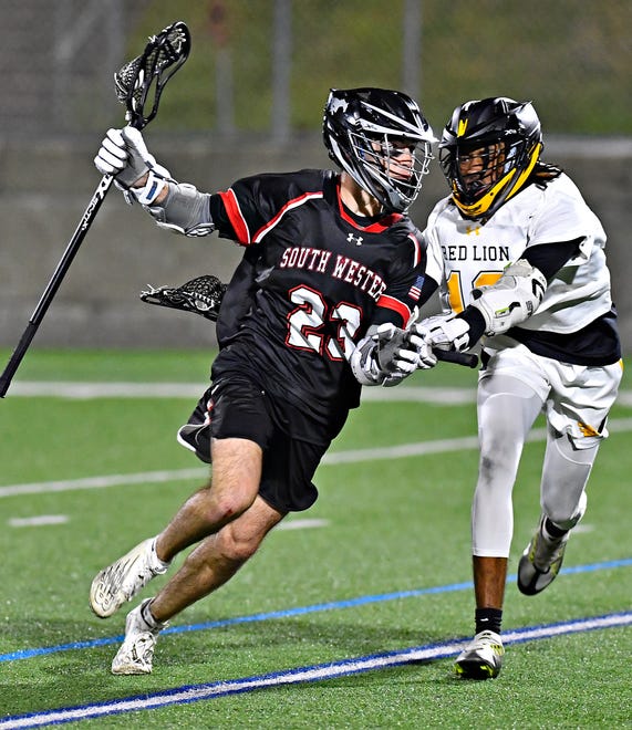 South Western’s Cole Dettinger, left, moves the ball down the field while Red Lion’s Raymond Barlow III defends during boys’ lacrosse action at Red Lion Area Senior High School in Red Lion, Tuesday, March 26, 2024. South Western would win the game 14-4.(Dawn J. Sagert/The York Dispatch)