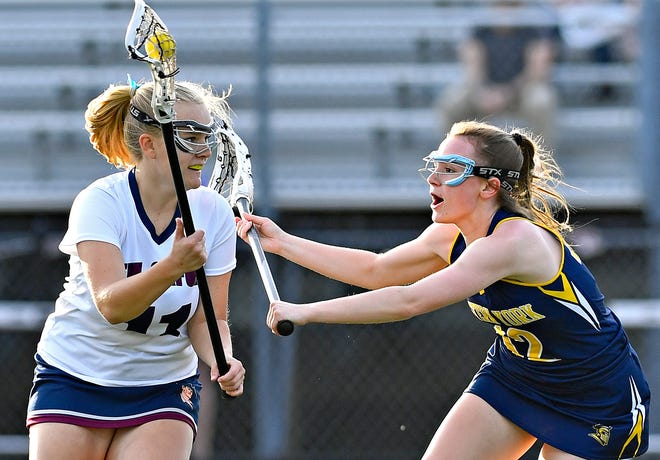 New Oxford’s Madison Cohee, left, moves the ball down the field while Eastern York’s Kiera Young defends during girls’ lacrosse action at New Oxford High School in Oxford Township, Tuesday, April 23, 2024. (Dawn J. Sagert/The York Dispatch)