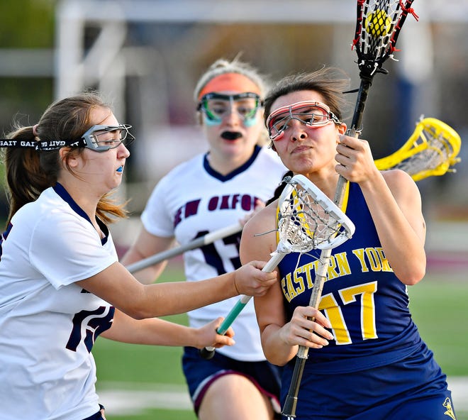 Eastern York’s Samantha Burke, right, moves the ball down the field while New Oxford’s Taylor Groft defends during girls’ lacrosse action at New Oxford High School in Oxford Township, Tuesday, April 23, 2024. (Dawn J. Sagert/The York Dispatch)