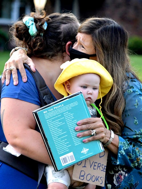 Delma Rivera, diversity education specialist at Central York School District, greets Hannah Shipley and her daughter Marnie, 8 months, as demonstrators gathered outside the Central York School District Administration offices before a school board meeting there Monday, Sept. 13, 2021. The rally was in opposition to a banned resource list instituted by the district, which demonstrators say targets minority authors. Shipley is a childcare provider for district families. Bill Kalina photo