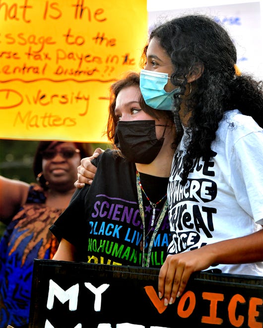 Panther Anti-Racist Student Union organizer Edha Gupta hugs union member Olivia Pituch, left, at rally outside the Central York School District Administration offices before a school board meeting there Monday, Sept. 20, 2021. The rally was in opposition to a banned resource list instituted by the district, which demonstrators say targets minority authors. District officials added formal discussion of the ban to Monday's agenda. Bill Kalina photo