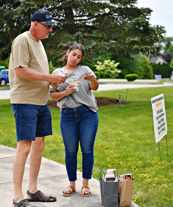 Esperanza Trevino, right, of Windsor Township, promotes the Central York School Board Republicans as she hands a flyer to Mike Gurgul, of Manchester Township, as he arrives to vote during Primary Election Day at the Zion Lutheran Church polling location in Manchester Township, Tuesday, May 16, 2023. Dawn J. Sagert photo